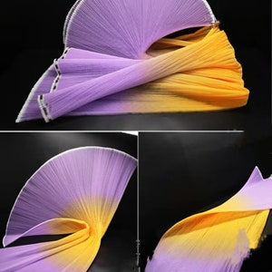 Peut inclure: Un &eacute;ventail en tissu pliss&eacute; d&eacute;grad&eacute; de violet &agrave; jaune. Le tissu est doux et fluide, et l'&eacute;ventail est parfait pour la danse ou les spectacles sur sc&egrave;ne.