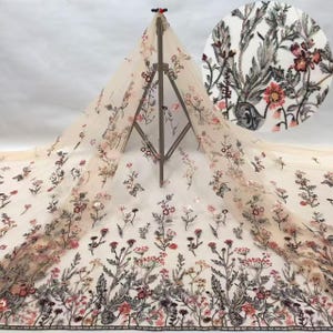 May include: A sheer beige tulle fabric featuring intricate embroidery of botanical stems, leaves, and flowers in shades of pink, red, and dark gray. The floral pattern is distributed across the mesh, with a circular inset showing a detailed view.