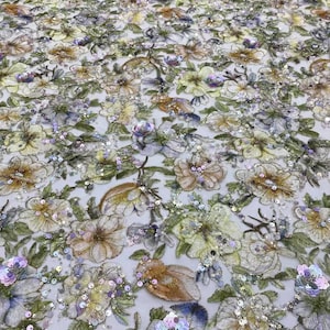 May include: A floral embroidered fabric with iridescent sequins in shades of green, yellow, purple, and blue. The fabric has a delicate, sheer texture and is perfect for creating unique garments or accessories.