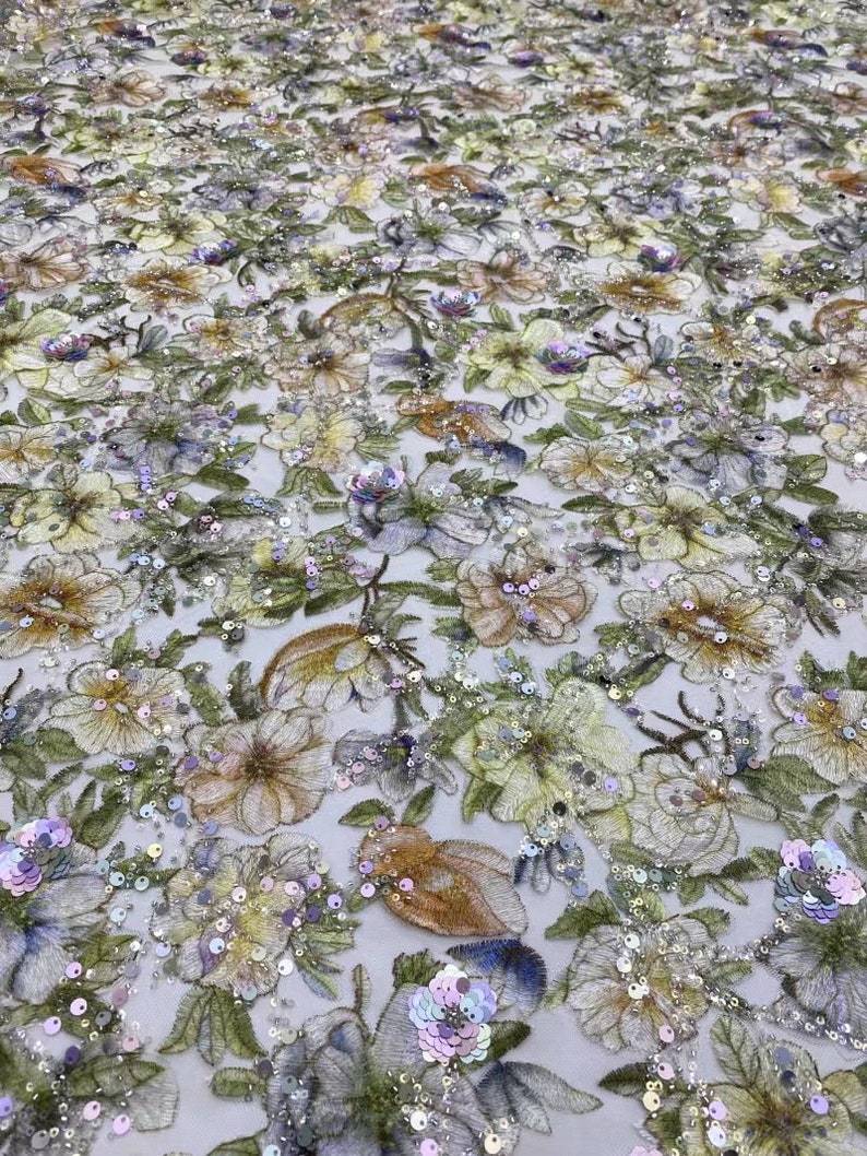 May include: A floral embroidered fabric with iridescent sequins in shades of green, yellow, purple, and blue. The fabric has a delicate, sheer texture and is perfect for creating unique garments or accessories.