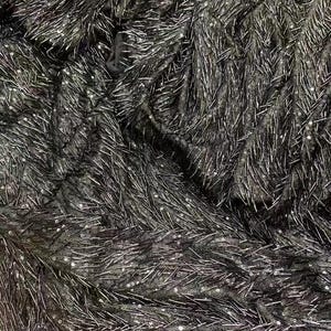 K&ouml;nnte beinhalten: Schwarzer Stoff mit einer strukturierten Oberfl&auml;che, die mit kleinen, silbernen Pailletten bedeckt ist. Die Pailletten sind in einem zuf&auml;lligen Muster angeordnet und erzeugen einen schimmernden Effekt.