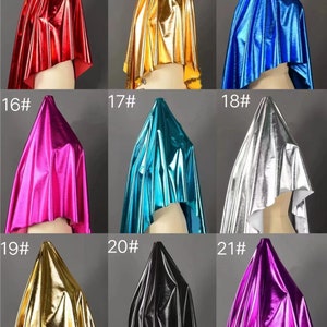 May include: A collection of 9 fabric swatches in various metallic colors, including red, gold, blue, pink, turquoise, silver, gold, black, and purple. Each swatch is draped over a mannequin head, with the number of the swatch displayed above it.