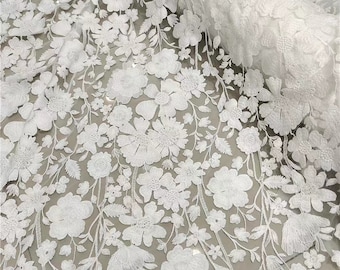 May include: White floral lace fabric with a delicate, intricate design. The lace features a repeating pattern of flowers and leaves, creating a romantic and elegant look.