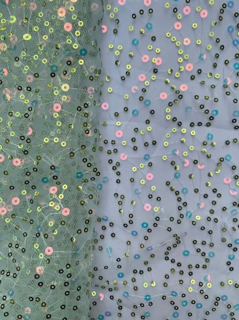 May include: Green, blue, and pink iridescent sequins on a sheer mesh fabric. The sequins are scattered randomly across the fabric.