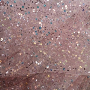 May include: Pink sheer fabric with iridescent sequins. The sequins are scattered randomly across the fabric.