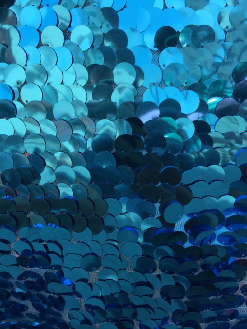 Puede incluir: Paillettes azul turquesa sobre una tela de malla. Las lentejuelas est&aacute;n dispuestas en un patr&oacute;n degradado, con lentejuelas m&aacute;s grandes en la parte superior y lentejuelas m&aacute;s peque&ntilde;as en la parte inferior.