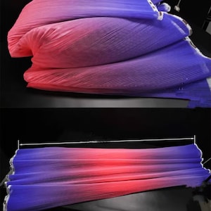 Peut inclure: Un tissu d&eacute;grad&eacute; dans des tons de rose, violet et bleu. Le tissu est pliss&eacute; et pr&eacute;sente une bordure blanche sur les bords.