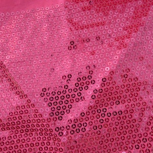 Op de afbeelding: Roze stof bedekt met kleine, ronde pailletten. De pailletten zitten dicht op elkaar en cre&euml;ren een glinsterend effect.