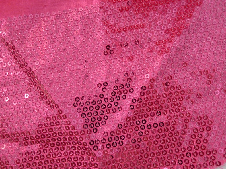Op de afbeelding: Roze stof bedekt met kleine, ronde pailletten. De pailletten zitten dicht op elkaar en cre&euml;ren een glinsterend effect.