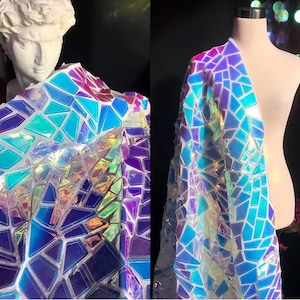 Puede incluir: Una tela iridiscente con un patrón geométrico de azul, morado y verde. La tela está hecha de un material transparente con un acabado holográfico.