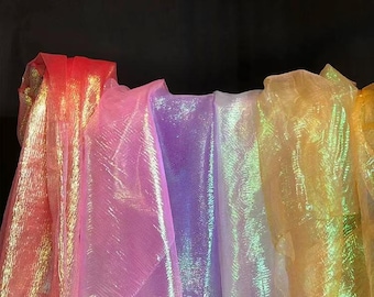 May include: A collection of iridescent sheer fabric in various colors, including pink, purple, white, and yellow. The fabric is translucent and has a shimmering effect.