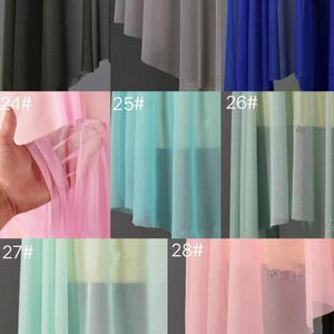 May include: A collection of eight different sheer fabrics in various colors, including green, gray, blue, pink, and turquoise. The fabrics are arranged in rows of two, with each fabric labeled with a number from 21 to 28.