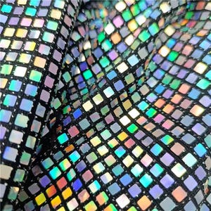 May include: Close-up of iridescent silver fabric with a grid pattern of small squares. The fabric has a subtle sheen and a textured surface.