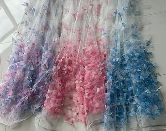 Può includere: Tre tessuti trasparenti, ciascuno ornato con abbellimenti floreali. Uno è un gradiente dal viola al rosa, il secondo è rosa e il terzo è blu. I tessuti sono probabilmente per l'artigianato o la moda, con un aspetto delicato e arioso.