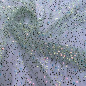May include: Pale green tulle fabric with iridescent sequins in a scattered pattern.