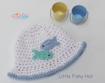May include: White crocheted sun hat with a blue trim and two blue and green fish appliques. The hat says "Little Fishy Hat" on the bottom.
