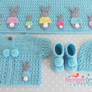 May include: A light blue crochet baby set with bunny appliques. The set includes a cardigan, hat, booties, and a blanket. The blanket has a row of bunnies with colorful accents.