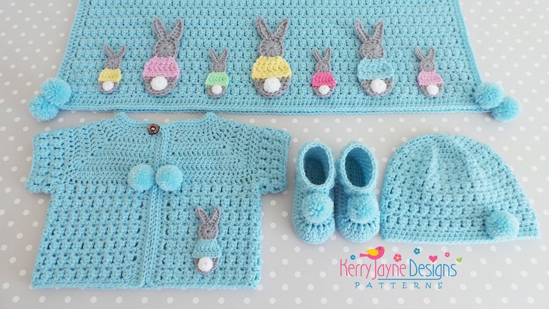 May include: A light blue crochet baby set with bunny appliques. The set includes a cardigan, hat, booties, and a blanket. The blanket has a row of bunnies with colorful accents.