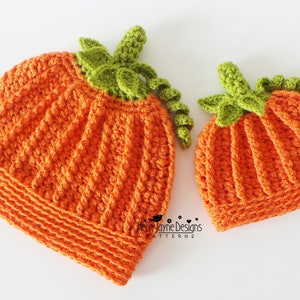 May include: Two crocheted pumpkin hats, one larger than the other, with green crocheted stems. The hats are orange and have a textured stitch pattern.