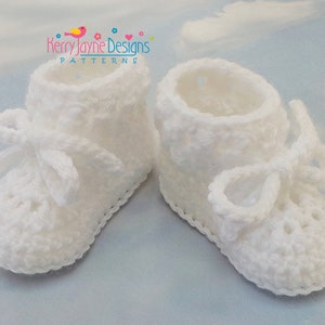 Puede incluir: Botitas de beb&eacute; de ganchillo blancas con un lazo en cada zapato. Las botitas tienen un delicado borde de encaje.