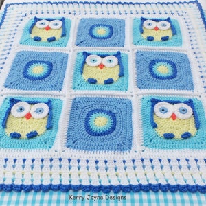 May include: A crocheted baby blanket with a blue, white, and yellow color scheme. The blanket features a repeating pattern of owls with large eyes. The blanket is bordered with a white and blue trim.