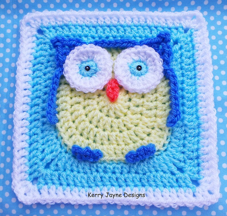 May include: A crocheted owl square with a yellow body, blue wings, white eyes, and a red beak. The owl is surrounded by a blue and white border.