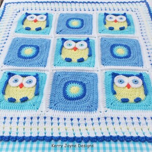 May include: A crocheted baby blanket with a blue, white, and yellow color scheme. The blanket features a repeating pattern of owls and circles. The blanket is bordered with a blue and white trim.