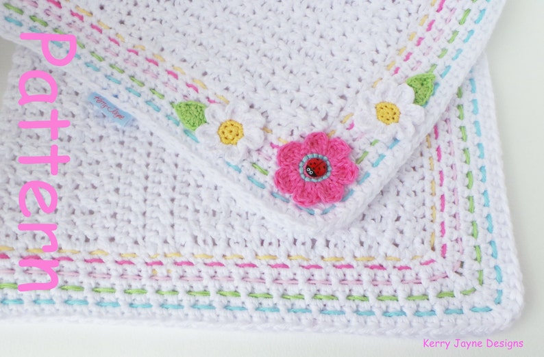 May include: White crochet baby blanket with a colorful border and flower appliques. The blanket has a pink flower with a ladybug in the center, and two white daisies with yellow centers. The border is made of multiple rows of different colored yarn.