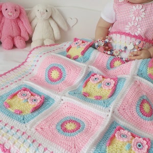 May include: A pink, blue, and white crocheted baby blanket with a pattern of owls. The blanket is made with soft yarn and has a delicate crocheted border.