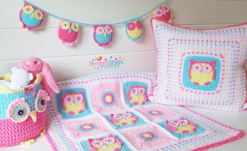 May include: A crocheted owl baby blanket, pillow, and toy basket set in pink, blue, and yellow. The set features a repeating owl design with flowers. The blanket is made of squares with different patterns, including a circle with a star in the center. The pillow is a square with an owl in the center. The toy basket is shaped like an owl with a pink, blue, and yellow color scheme. The set is perfect for a baby's nursery.