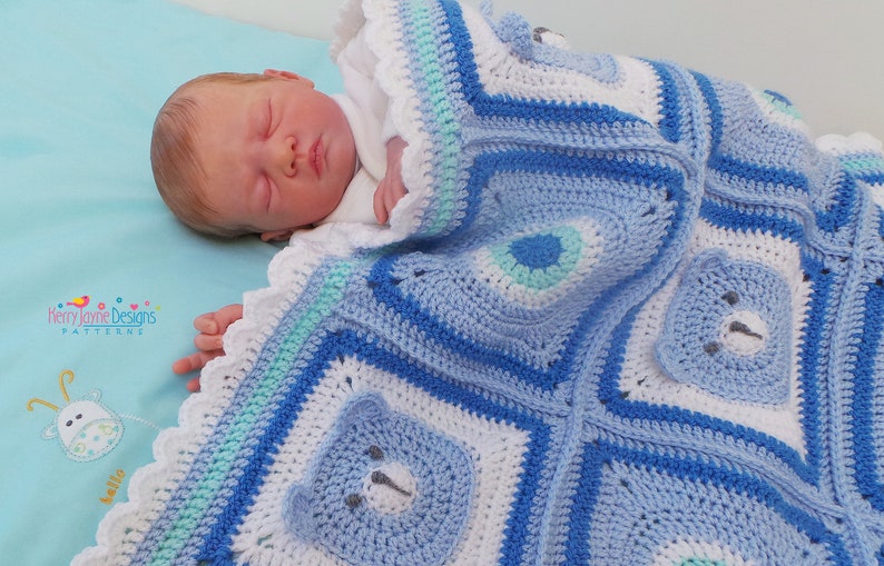 K&ouml;nnte beinhalten: Eine blaue und wei&szlig;e geh&auml;kelte Babydecke mit einem gewellten Rand und B&auml;ren-Applikationen. Die Decke ist mit verschiedenen Maschen und Texturen gearbeitet und hat ein hellblaues, wei&szlig;es und gr&uuml;nes Farbschema.