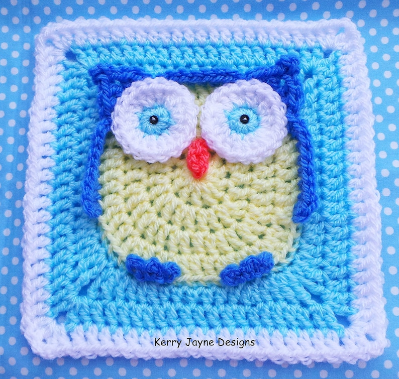 May include: A crocheted square featuring an owl design. The owl is yellow with blue eyes, a red beak, and blue feet. The square is bordered with white and blue crochet.