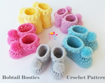 Puede incluir: Seis pares de botines de bebé tejidos a crochet en varios colores, incluyendo rosa, azul, amarillo y gris. Cada botín tiene un pequeño pompón en la parte superior. Los botines están dispuestos en un círculo sobre un fondo blanco. Bobtail Booties Crochet Pattern.
