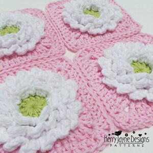 May include: Four pink crochet squares with white and green flowers in the center. The squares are arranged in a grid pattern. The text "Kerry Jayne Designs PATTERNS" is visible in the bottom right corner.