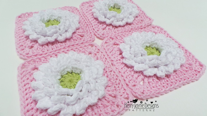 May include: Four pink crochet squares with white and green flowers in the center. The squares are arranged in a grid pattern. The text "Kerry Jayne Designs PATTERNS" is visible in the bottom right corner.