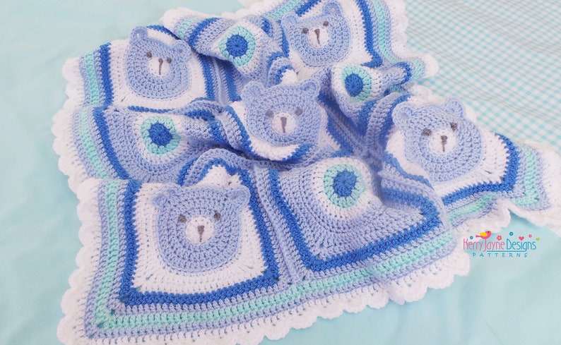 K&ouml;nnte beinhalten: Eine blaue und wei&szlig;e geh&auml;kelte Babydecke mit einem B&auml;renmotiv. Die Decke hat einen gewellten Rand und ist mit verschiedenen Maschen gearbeitet.