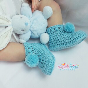 Puede incluir: Un par de botitas de beb&eacute; de crochet azul con pompones. Las botitas tienen un dise&ntilde;o de encaje y son perfectas para un regalo de baby shower.