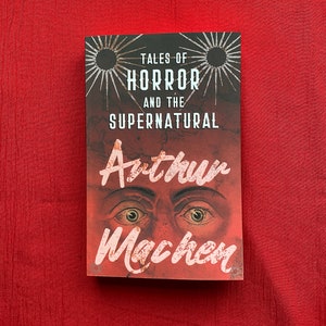 May include: A book titled "Tales of Horror and the Supernatural" by Arthur Machen. The cover features a pair of eyes with a red background and a starburst design.