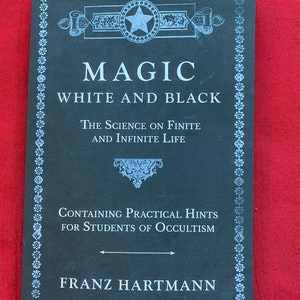 May include: A black book with a white border and a star design on the cover. The title is "Magic White and Black: The Science on Finite and Infinite Life. Containing Practical Hints for Students of Occultism." The author is Franz Hartmann.
