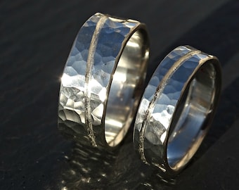 May include: Two silver wedding bands with a hammered finish and a thin line down the center.