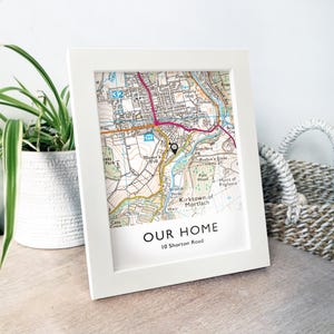 May include: A white framed map print featuring a detailed street map. The map includes roads, buildings, and geographical details. The text "OUR HOME" and the address "10 Shorton Road" are printed at the bottom of the frame.