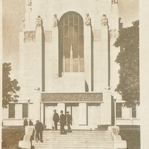 Può includere: Una fotografia in bianco e nero dell'Anzac Memorial a Sydney, Australia. Il memoriale è un grande edificio bianco con un grande arco al centro. Ci sono diverse figure sull'edificio e un gruppo di persone è in piedi di fronte al memoriale.