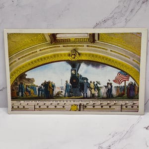 May include: Vintage postcard featuring a mural painting of a steam train at Union Station in Salt Lake City, Utah. The artwork depicts a crowd of people observing the train. The text reads "Scene at the Completion of the U.P.R.R. Mural Painting, Union Station, Salt Lake City, Utah."