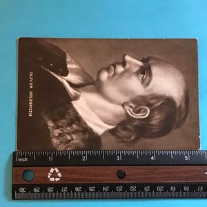 May include: A black and white portrait of Oliver Goldsmith, a famous Irish writer and poet. The image is printed on a card.