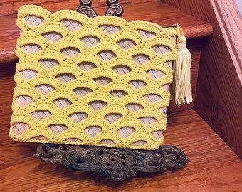 Yellow crocheted clutch over straw clutch
