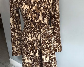 May include: A brown and cream leopard print wrap dress with long sleeves and a tie belt.