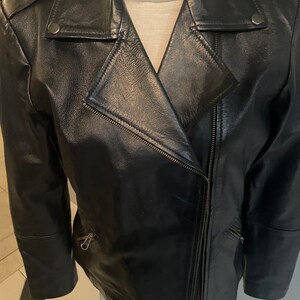 May include: A black leather motorcycle jacket with a zipper closure and a snap button detail on the collar.