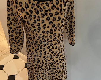 May include: A brown and black leopard print dress with a black trim around the neckline. The dress has a fitted bodice and a flared skirt.