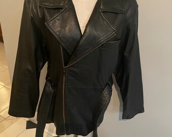 May include: A black leather jacket with a zipper closure and a belt. The jacket has a stand-up collar and long sleeves.