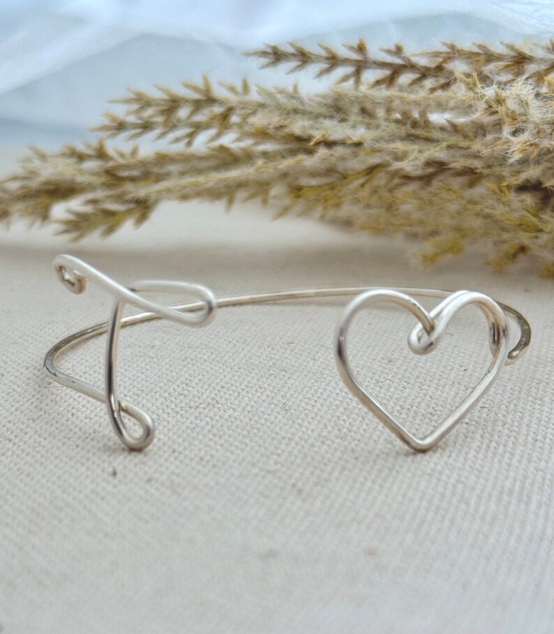 Sterling Silver 16 gauge wire initial heart bangle, hand shaped and formed, on linen display